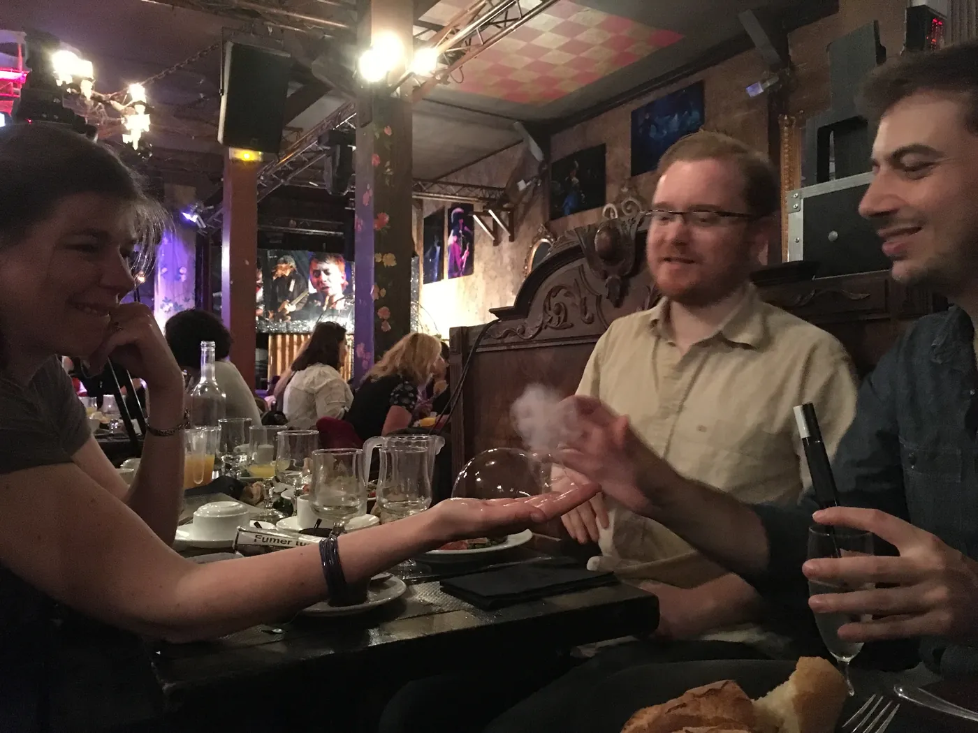 Une bulle passe dans la main d'une invitée, à table