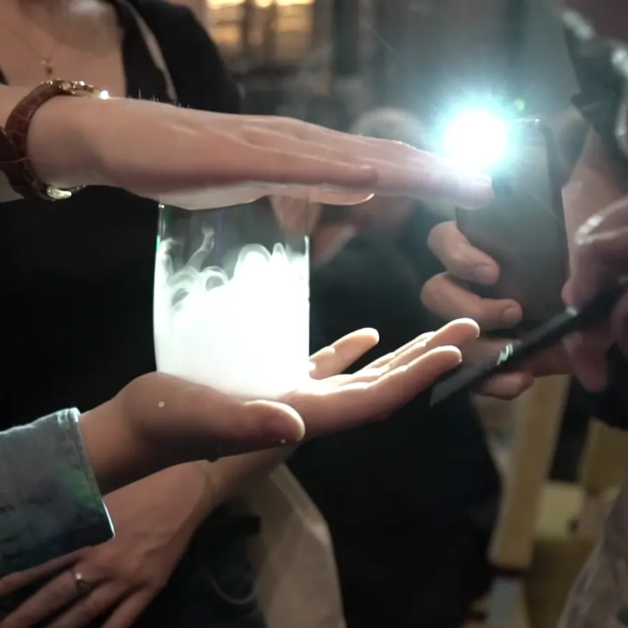 Une bulle de fumée s'illumine entre les mains d'invités